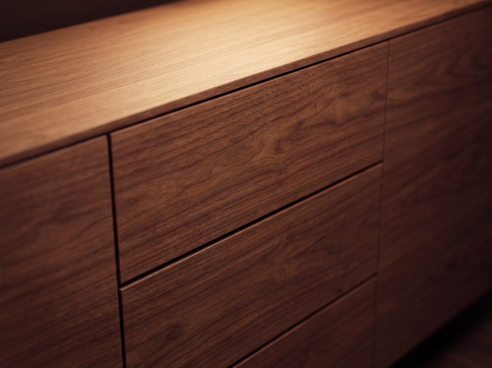 Sideboard-Fronten in Nussbaum furniert, die Maserung läuft waagerecht über drei Schubkästen durch, Visualisierung